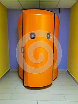 Orange vertical tanning booth.
