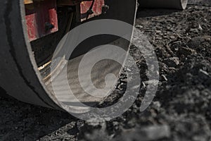 Orange Vibration roller compactor standing on a ground near asphalts road at road construction and repairing asphalt