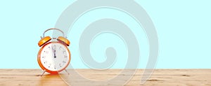 Orange vintage clock on teal background showing nearly 12, last minute concept photo