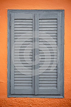 Orange wall with vintage window blinds