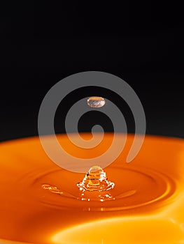 Orange water drop with black background