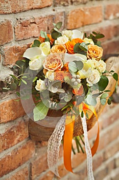 Orange wedding bouquet on a brick background