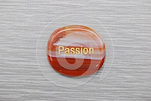 Orange and white passion mood stone on a gray background