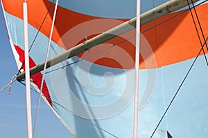 An orange and white stripey sail on the end of a pole photo