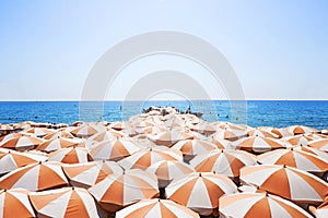 Orange white sun umbrellas on a beach at south french coast