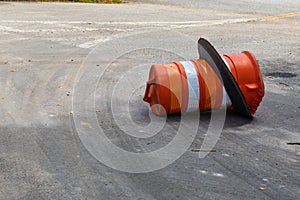 Orange and white traffic barrel knocked over on its side, traffic accident reckless driving photo