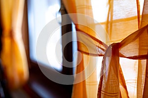 Orange window curtain close up shot, shallow depth of field