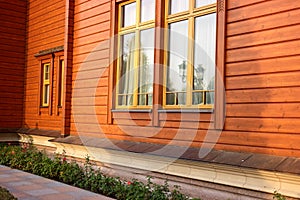 Orange wood house facade with flowers.