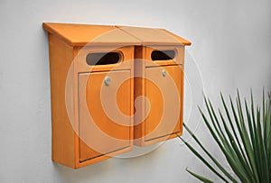 Orange wooden letter boxes on white wall