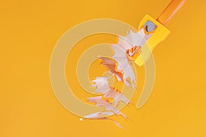 Orange wooden pencil with shavings in a stationery sharpener on an orange background.