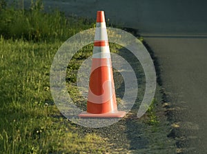 Orange work zone cone on side of road