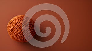 orange yarn ball on brown background.