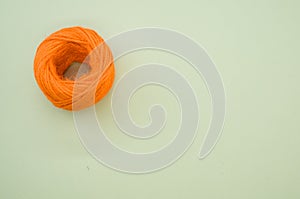Orange yarn ball for knitting isolated on gray background