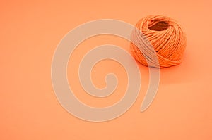 Orange yarn ball for knitting isolated on orange background