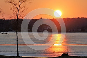 Orange and yellow sunset over frozen lake