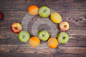 Oranges apples and lemons on wooden background