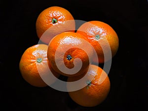 Oranges on a black surface