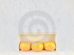 Oranges in box on blue baackground.