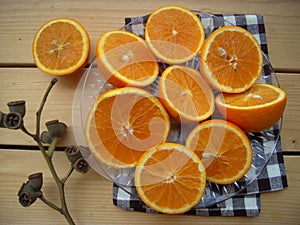 Oranges cut into halves, prepared for make juice, and dry sprig, still life .
