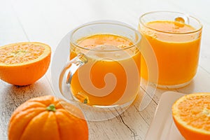 Oranges and fresh squeezed orange juice close up on wooden background, flat lay