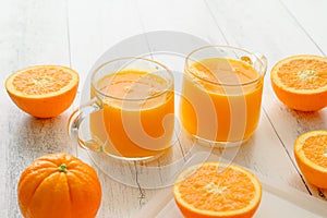 Oranges and fresh squeezed orange juice close up on wooden background, flat lay