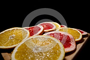 Oranges fruit on black wooden boards. Halves of juicy orange on black background. Orange fruit, citrus minimal concept. Top view,