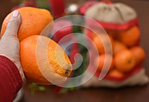 oranges in hand and a bag of tangerines