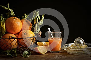 Oranges juice on wooden table with black background