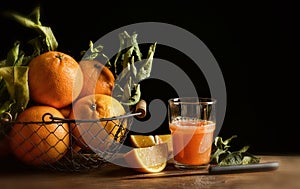 Oranges juice on wooden table with black background