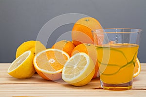 Oranges and lemon with slices and glass of fresh orange juice