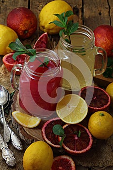 Oranges and lemons on a wooden background. Orange and lemon juice
