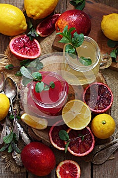 Oranges and lemons on a wooden background. Orange and lemon juice