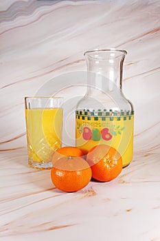 Oranges and orange juice in carafe and glass.