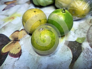 3 oranges on the table in yellowish green color photo