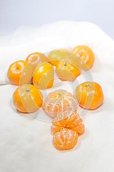 Oranges on white cloth which as the background.