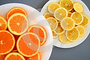 oranges and yellow lemons on a plate on a sunny day photo