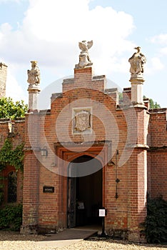 Orate arched entrance with statues and coat of arms