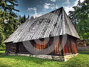 Krásně staré dřevěné domy v krásné přírodě plné stromů a květin.Slovensko