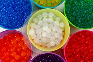 Orbeez toy, close-up. Hydrogel balls or Water beads in plastic cups, top view. Flexible gel balls for playing