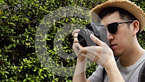 Orbit circle shot of young male travel photographer tourist taking photos in nature scene