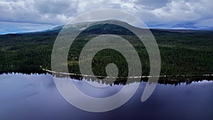 Orbit shot over dark blue freshwater forest mountain lake in Dalarna Sweden