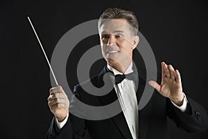 Orchestra Conductor Looking Away While Directing With His Baton