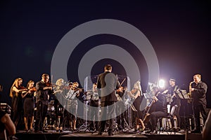 Orchestra performing live concert under blue night sky