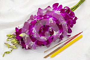 Orchid bouquet, a candle and three incense sticks to offer Buddhist monk or Buddha image