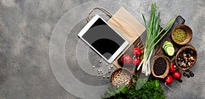 Order, delivery food. Vegetables Organic food products on a wooden board with tablet computer and shopping paper bag