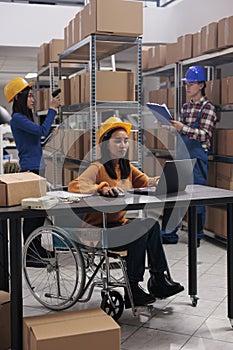 Order fulfillment warehouse worker in wheelchair doing stock management