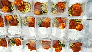 an order of nasi box containing white rice, eggs and Balinese tofu, accompanied by vegetable fried noodles