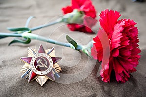 Order of the patriotic war 1st class and two red carnations. May 9