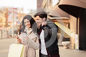 Order taxi online. Couple using smartphone after shopping