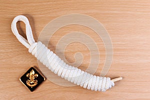 Orderliness white scout rope with vintage boy scouts badge on wooden table.